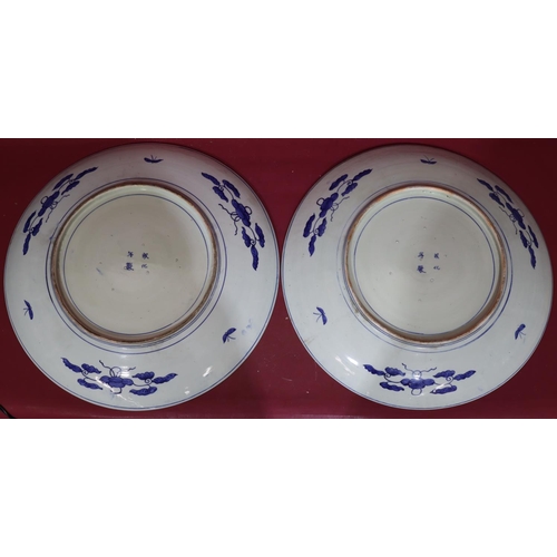 218 - A pair of large 19th/20th Century round chargers on blue and white ground with bird, branch, floral ... 