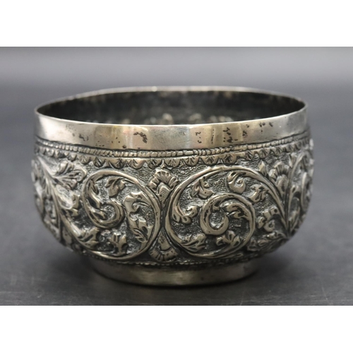 299 - An Eastern silver coloured metal small round bulbous shaped bowl with embossed leaf and scroll decor... 