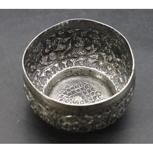 299 - An Eastern silver coloured metal small round bulbous shaped bowl with embossed leaf and scroll decor... 