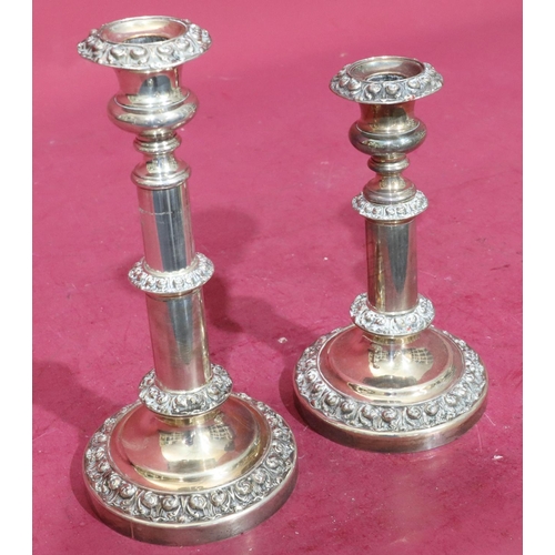 367 - A pair of silver plated telescopic candlesticks with embossed floral and scroll decoration on round ... 