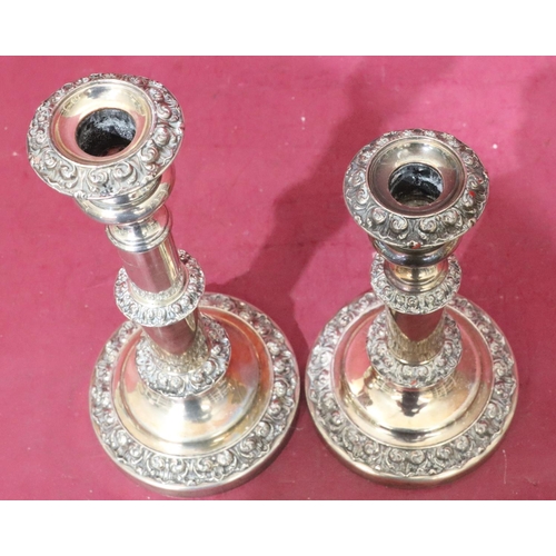 367 - A pair of silver plated telescopic candlesticks with embossed floral and scroll decoration on round ... 