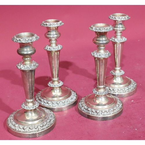 368 - A set of 4 silver plated candlesticks on turned stems with raised floral and scroll decoration on ro... 