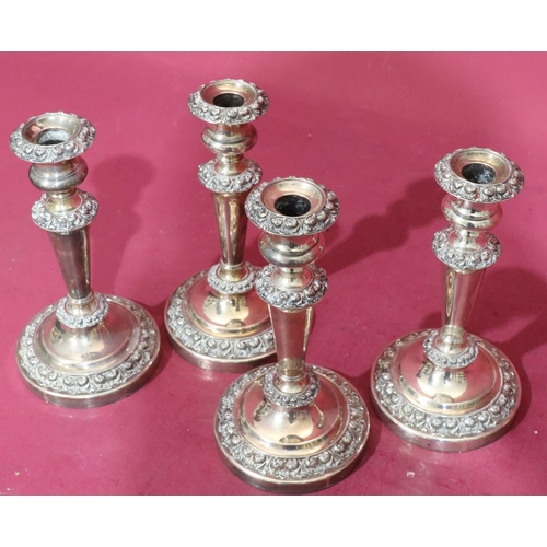 368 - A set of 4 silver plated candlesticks on turned stems with raised floral and scroll decoration on ro... 