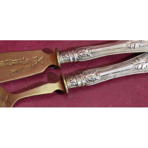 377 - A pair of 800 silver coloured metal handled fish servers with engraved scroll decoration in fitted g... 