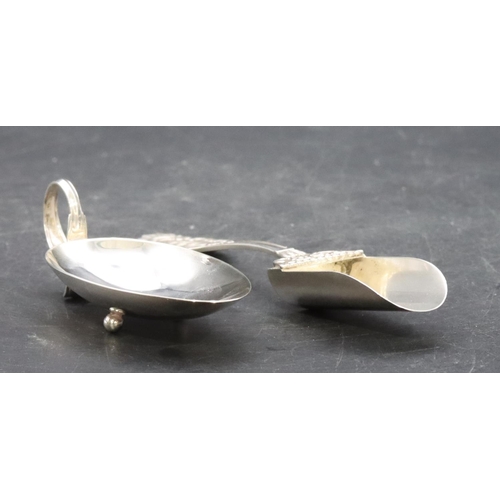 381 - An 800 silver coloured metal egg shaped spoon with scroll handle and ball feet, an 800 silver colour... 