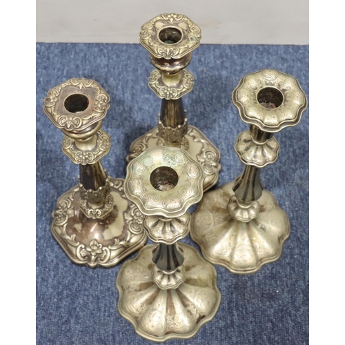 405 - A pair of silver plated candlesticks on turned stems with square scallop shaped bases and embossed l... 