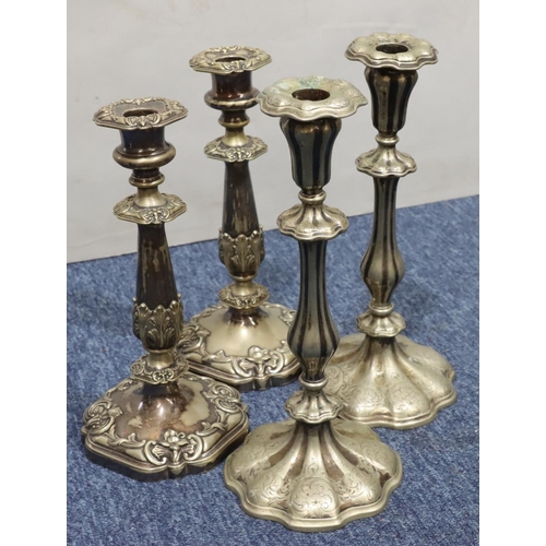 405 - A pair of silver plated candlesticks on turned stems with square scallop shaped bases and embossed l... 