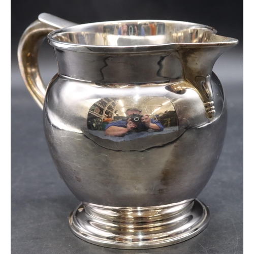 414 - A George V silver round bulbous shaped jug with scroll handle on sweeping foot, London 1931, stamped... 