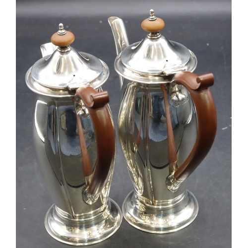 415 - A pair of George V small round bulbous shaped teapot and matching hot water jug with brown wooden sc... 