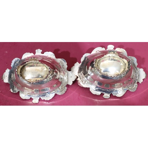 416 - A pair of Victorian oval scallop shaped bonbon dishes with raised floral, leaf and scroll rims on sp... 