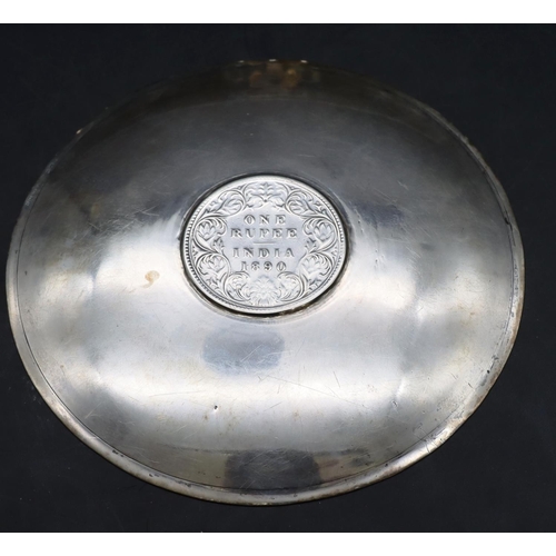 421 - A small Indian silver coloured metal circular dish inset with one rupee 1890, 1.4oz, (boxed).