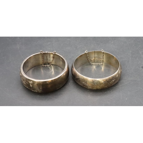 443 - 2 wide band hinged bangles with engraved decoration, 64.3 grams (2)