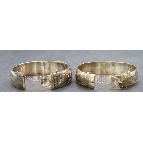 443 - 2 wide band hinged bangles with engraved decoration, 64.3 grams (2)