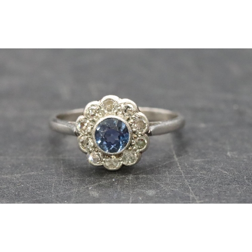 488 - A platinum ladies' circular cluster ring set with centre sapphire surrounded by small diamonds, Size... 