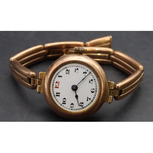 499 - A 9ct gold circular wristwatch with white enamel dial and Arabic numerals, 9ct gold expanding strap ... 