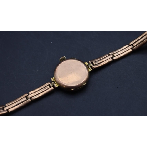 499 - A 9ct gold circular wristwatch with white enamel dial and Arabic numerals, 9ct gold expanding strap ... 