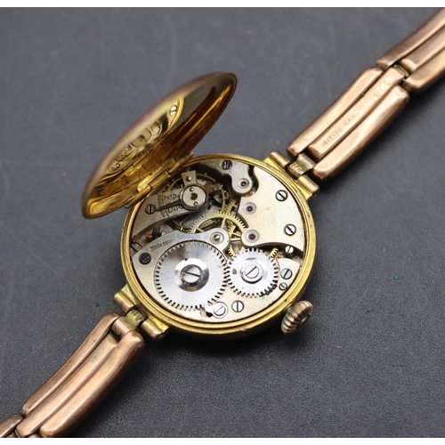 499 - A 9ct gold circular wristwatch with white enamel dial and Arabic numerals, 9ct gold expanding strap ... 