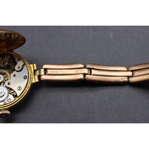 499 - A 9ct gold circular wristwatch with white enamel dial and Arabic numerals, 9ct gold expanding strap ... 