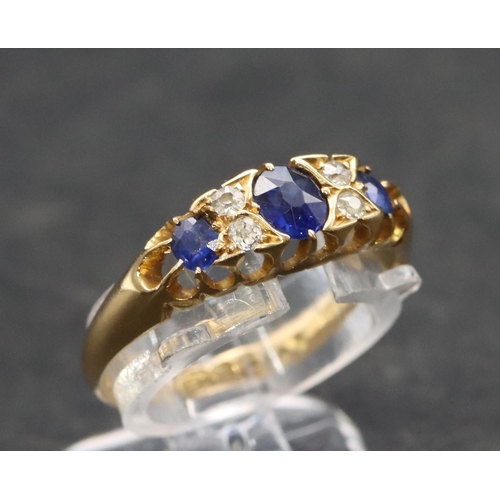 504 - An 18ct gold ladies' boat shaped ring set with 3 graduated sapphires interspersed by 4 small diamond... 