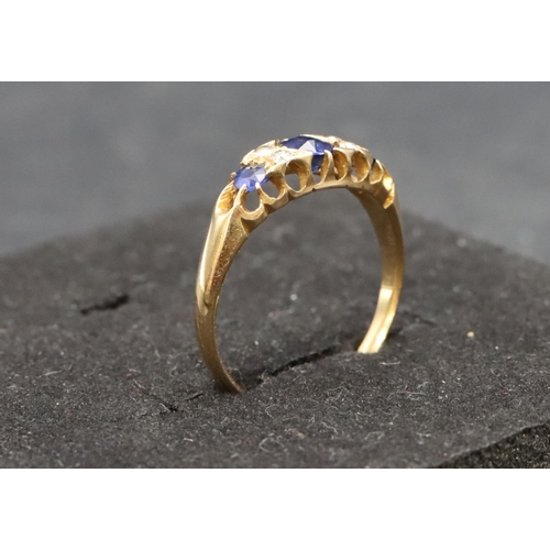 504 - An 18ct gold ladies' boat shaped ring set with 3 graduated sapphires interspersed by 4 small diamond... 