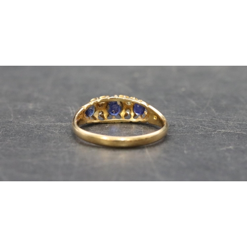 504 - An 18ct gold ladies' boat shaped ring set with 3 graduated sapphires interspersed by 4 small diamond... 