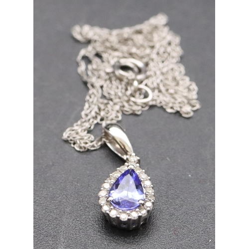 541 - A small 9ct gold pendant with chain set with blue stone surrounded by small diamond chips