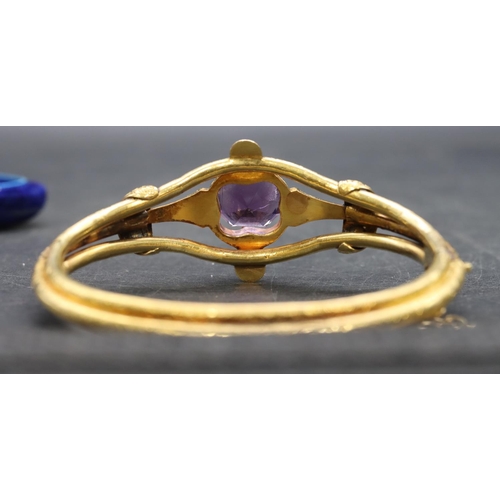 550 - A 19th Century Russian high carat gold hinged bangle set with centre amethyst flanked by half pearls... 