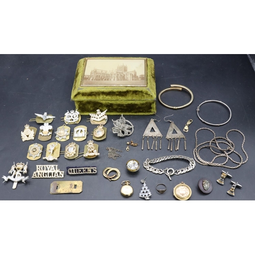 555 - A circular locket, a small quantity of various jewellery and a small quantity of various cap badges