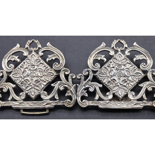 561 - A London silver nurses buckle with pierced scroll and floral decoration, 8.5cm wide, 43.4 grams