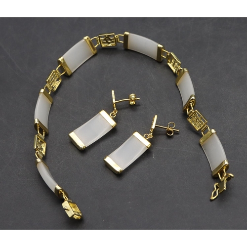 571 - A gilt metal and white hardstone panelled bracelet with a pair of matching earrings (3)