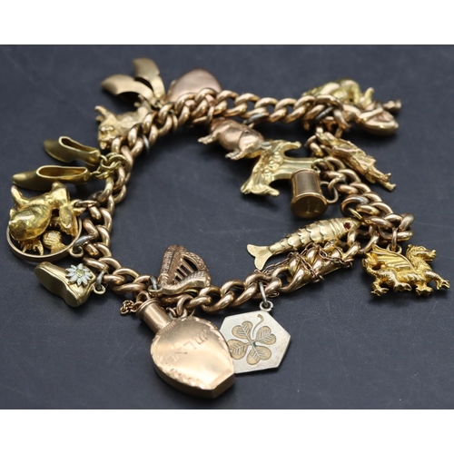 591 - A 15ct gold linked bracelet mounted with 18 charms ( mostly 9ct, 1 x 14ct and 2 x silver), 46.3 gram... 