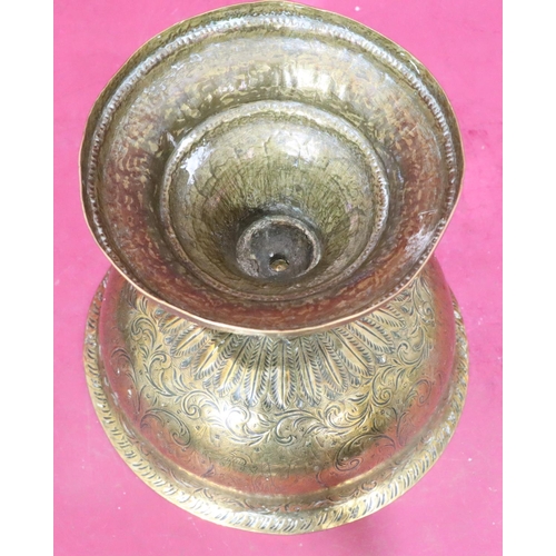 611 - An Indian brass round bulbous trumpet shaped bowl on sweeping foot with engraved figure and scroll d... 