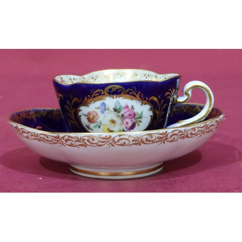 63 - A Meissen oval scallop shaped cup and saucer on royal blue ground with hand painted floral, leaf and... 