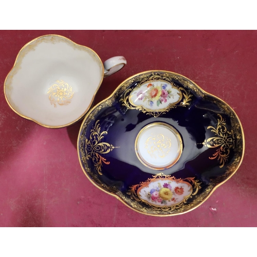 63 - A Meissen oval scallop shaped cup and saucer on royal blue ground with hand painted floral, leaf and... 