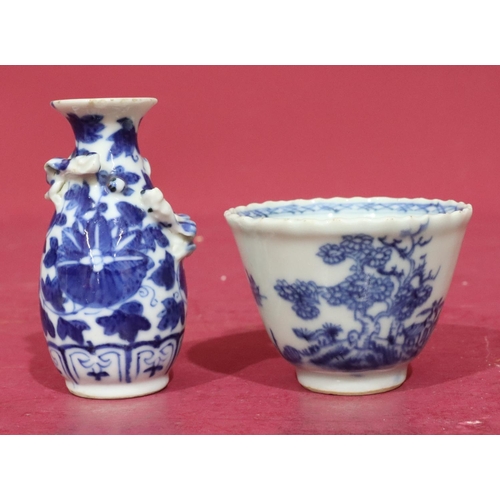 64 - An 18th/19th Century round trumpet shaped tea bowl on blue and white ground with tree and landscape ... 