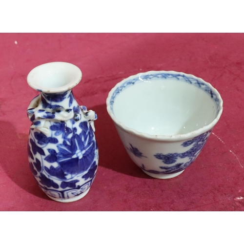 64 - An 18th/19th Century round trumpet shaped tea bowl on blue and white ground with tree and landscape ... 