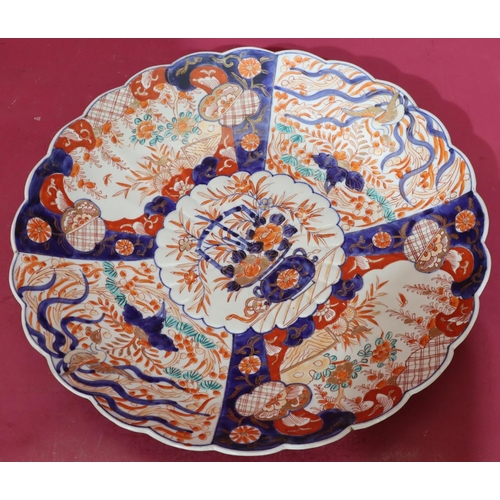 74 - An Imari large round scallop shaped charger on white, blue and red ground with allover floral, leaf,... 