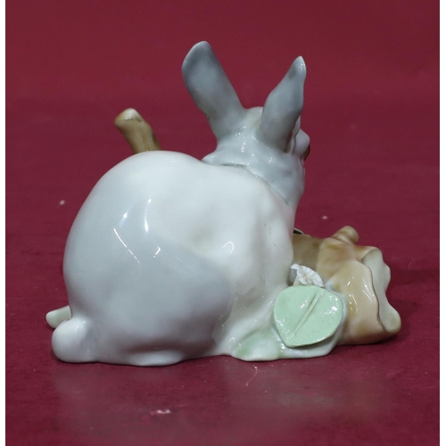 75 - A Lladro figure of a rabbit resting next to a log (encrusted flowers slight chips), 12cm wide