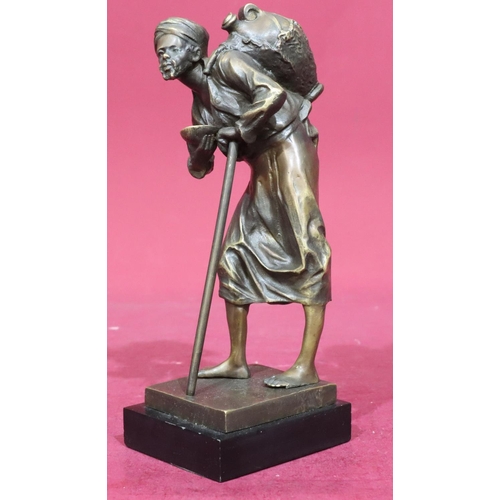 809 - A gilt metal figure of an elderly gentleman with staff carrying bottle upon his back, on rectangular... 