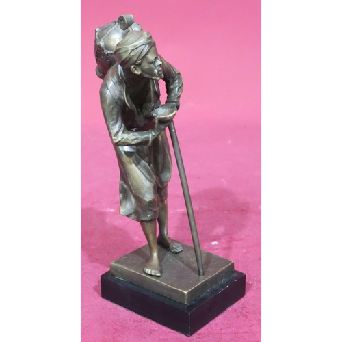 809 - A gilt metal figure of an elderly gentleman with staff carrying bottle upon his back, on rectangular... 