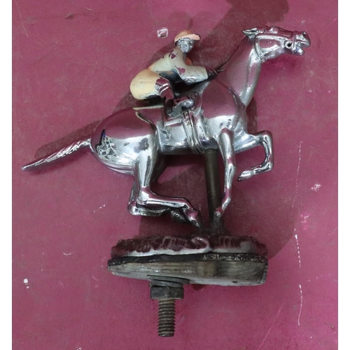 811 - A car mascot in the form of a jockey on horseback, 13.5cm wide, 14.5cm high including screw