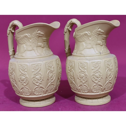 82 - A pair of Buff Canova round bulbous shaped jugs with raised mythical winged beasts, scroll and flora... 