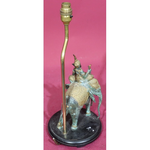 824 - An Eastern bronze and gilt metal table lamp in the form of a figure riding 3-headed elephant, mounte... 