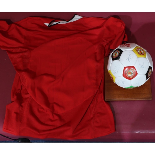 831 - A signed Manchester United signed football, donated by Bobby Charlton Teamwear 1994, with stand and ... 