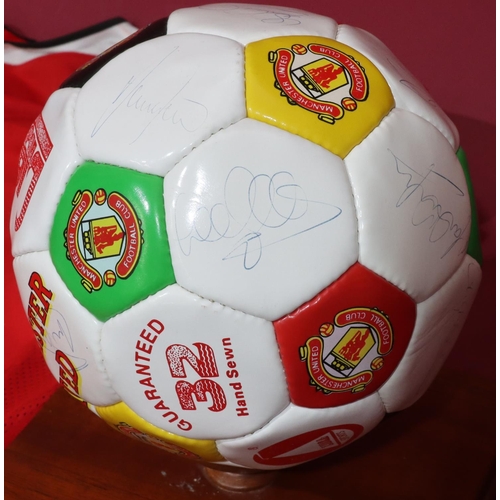 831 - A signed Manchester United signed football, donated by Bobby Charlton Teamwear 1994, with stand and ... 