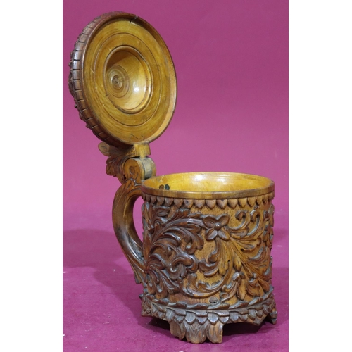 837 - A Continental carved treen beer stein with hinged lid with allover raised floral and leaf decoration... 