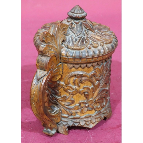 837 - A Continental carved treen beer stein with hinged lid with allover raised floral and leaf decoration... 