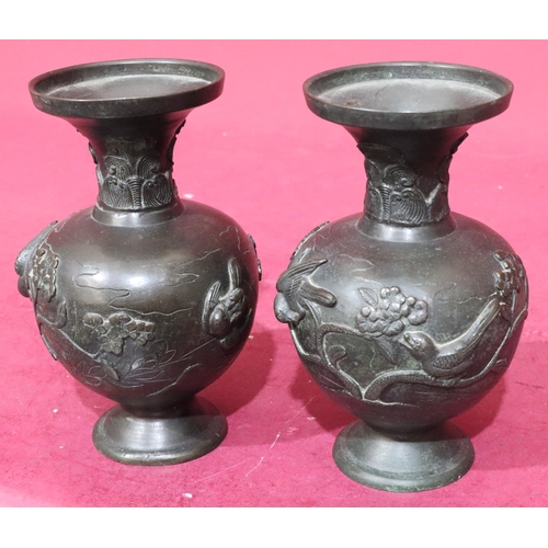 842 - A pair of Oriental bronze round bulbous thin neck trumpet shaped vases with raised bird, branch and ... 