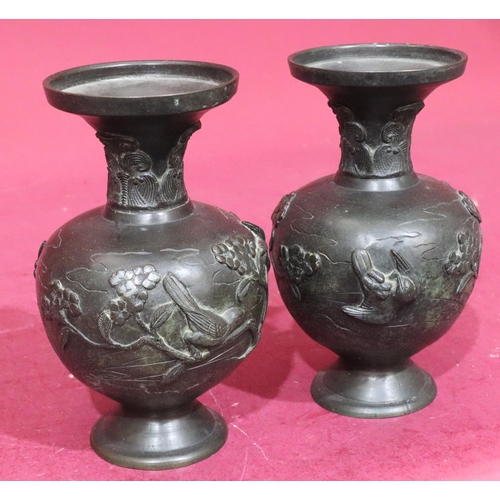 842 - A pair of Oriental bronze round bulbous thin neck trumpet shaped vases with raised bird, branch and ... 