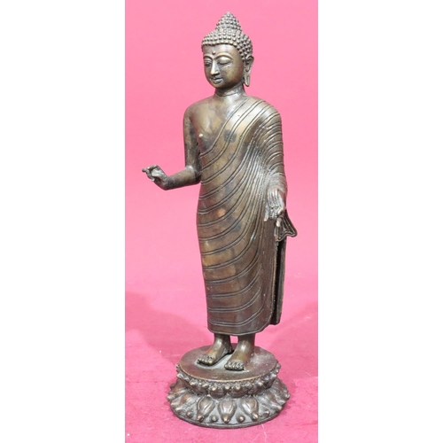 843 - A bronze figure of a standing Buddha on round base, 37.5cm high